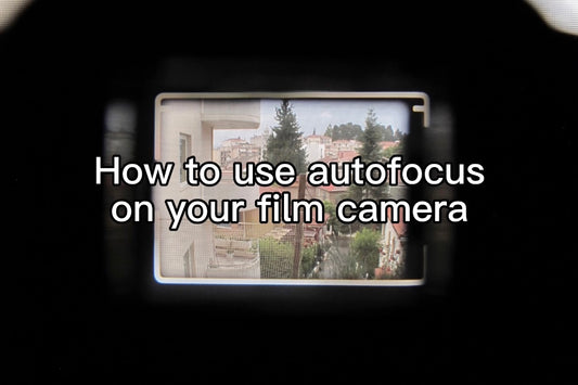 looking through the viewfinder of a film camera to use the autofocus feature