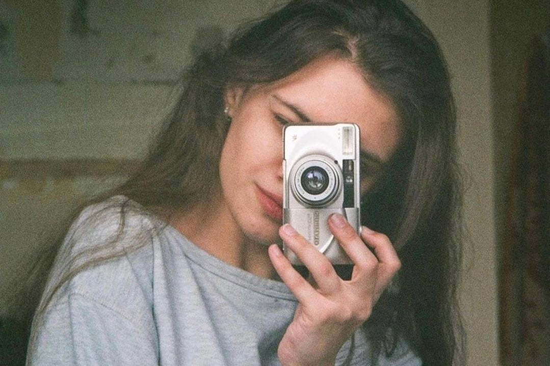 girl holdign a vintage Olympus 35mm film camera
